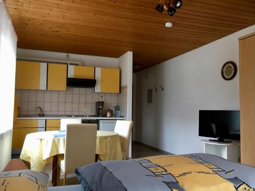eine Küche und ein Esszimmer mit einem Tisch und Stühlen in der Unterkunft Ferienwohnung am Kirschbaum in Uhldingen-Mühlhofen