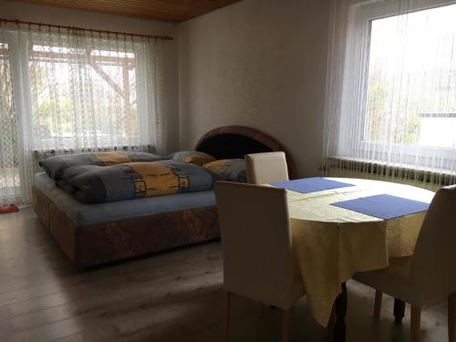 Schlafzimmer mit einem Bett, einem Tisch und Stühlen in der Unterkunft Ferienwohnung am Kirschbaum in Uhldingen-Mühlhofen