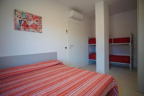 1 dormitorio con 1 cama y 2 literas en Quito Residence movida e spiaggia, en Lido di Jesolo