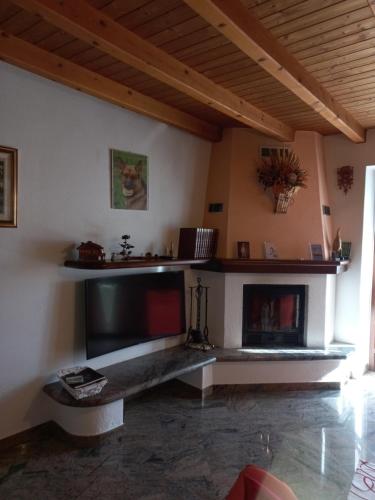 a living room with a tv and a fireplace at casa vacanza da ghislin in Teglio