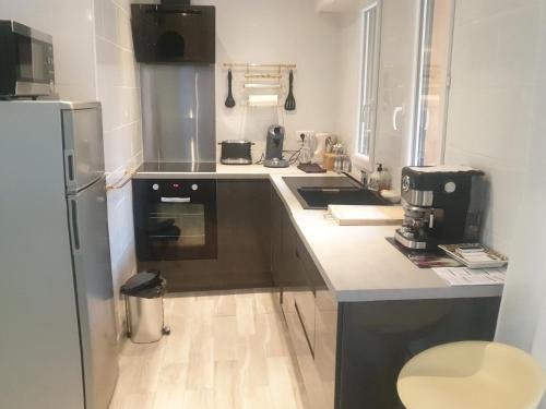 une petite cuisine avec un comptoir et un réfrigérateur dans l'établissement petit coin ensoleillé, à Beausoleil