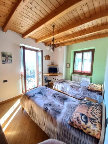 two beds in a room with two windows at casa vacanza da ghislin in Teglio