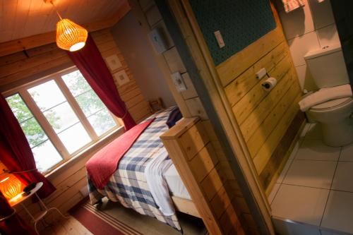 Dormitorio pequeño con cama y aseo en Manoir du Lac Sept-Îles en Saint-Raymond
