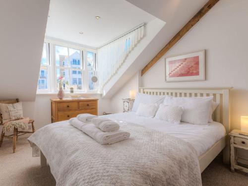 a bedroom with a white bed with two towels on it at Alfred Wallis in St Ives
