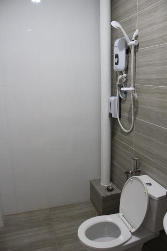 a bathroom with a toilet and a shower at Hotel Decentraland Kuala Terengganu in Kuala Terengganu