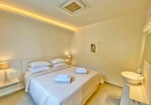 a white bedroom with a bed and a sink at Paleopetres K-Three - Premium Double Suite - Kalami - in Kalami