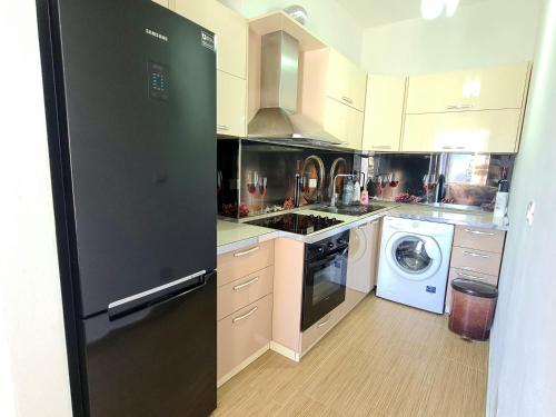 uma cozinha com um frigorífico preto e uma máquina de lavar louça em Appartment Lura 3 em Durrës