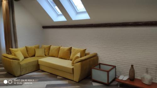 a yellow couch in a living room with a window at White House in Bălţi
