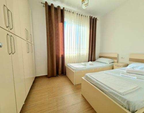 um quarto com duas camas e uma janela em Appartment Lura 3 em Durrës