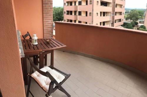 a wooden table and a chair on a balcony at Accogliente e spazioso appartamento a Cecina in Cecina