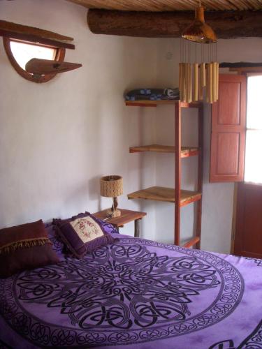 a bedroom with a large purple bed in a room at La Calabaza Cabaña in Tilcara