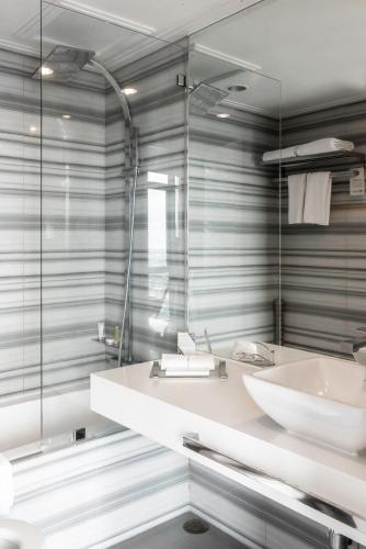 a bathroom with a white sink and a mirror at Astoria Palawan in Puerto Princesa City