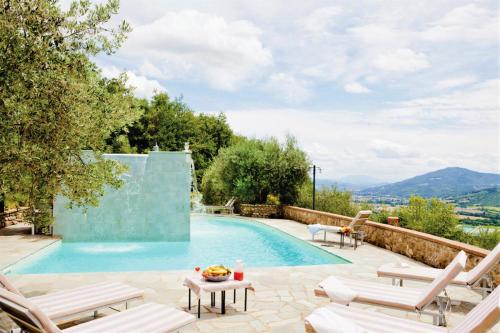 a swimming pool with two chairs and a table next to it at Villa Montecastelli by Mmega in Niccone