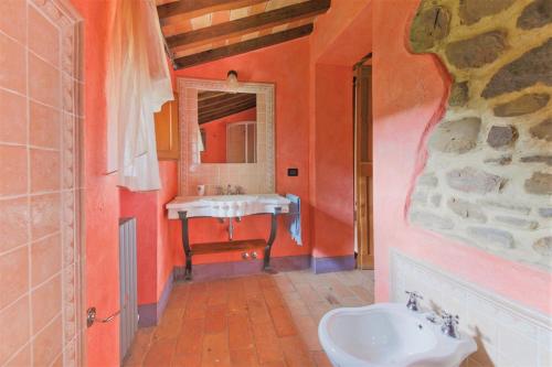 y baño con lavabo blanco y espejo. en Villa Montecastelli, en Niccone