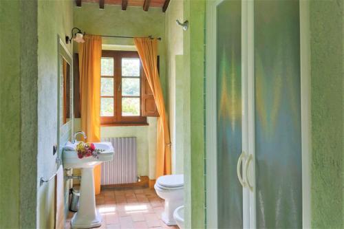 a bathroom with a sink and a toilet and a window at Villa Montecastelli by Mmega in Niccone
