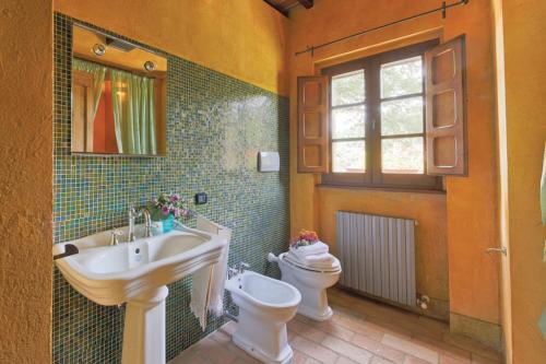 a bathroom with a sink and a toilet and a window at Villa Montecastelli by Mmega in Niccone