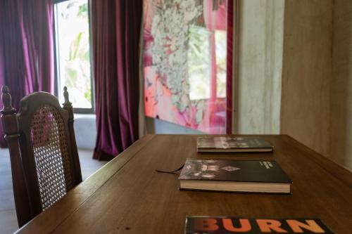 a wooden table with a book and a book at Casa Malca in Tulum