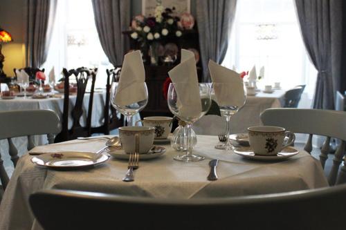 una mesa con mantel blanco y copas de vino en Fennessy's Hotel en Clonmel