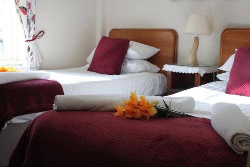 a bedroom with two beds with red and white at Fennessy's Hotel in Clonmel