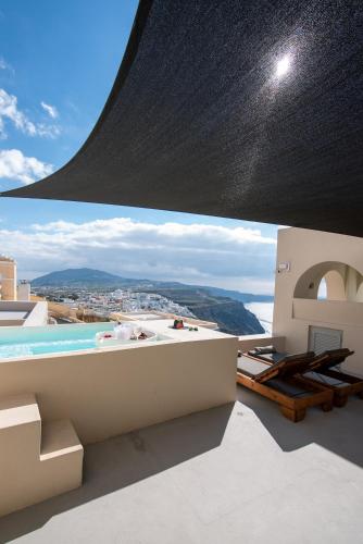 a view from the balcony of a house with a swimming pool at Caldera Cliff Illusion in Fira
