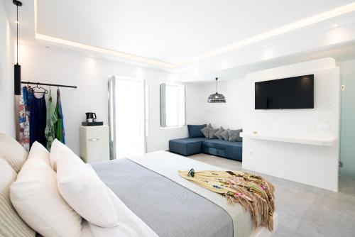 a bedroom with a large bed with a tv on the wall at Caldera Cliff Illusion in Fira
