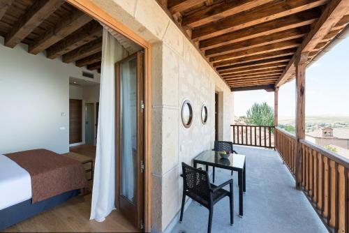 
a patio area with a bed, table and chairs at Áurea Convento Capuchinos by Eurostars Hotel Company in Segovia
