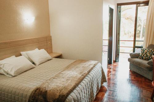 a bedroom with a bed and a couch and a window at Colinas Executive Park Hotel in Giruá