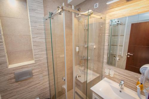 a bathroom with a glass shower and a sink at HARIZMA 013 in Kovin