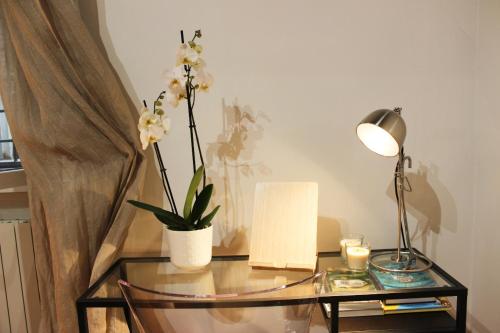 a glass table with a lamp and flowers on it at Pantheon Grand Suite in Rome