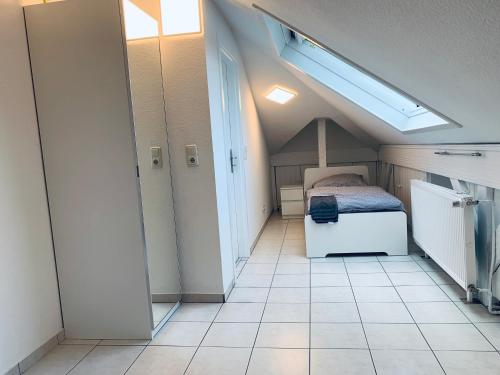 ein kleines Schlafzimmer mit einem Bett und Fliesenboden in der Unterkunft 3 Room Apartment in Wiesbaden in Wiesbaden