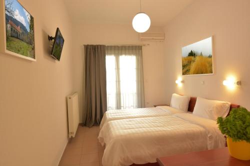 a hotel room with a bed and a window at Hotel Villa Drosos in Litochoro