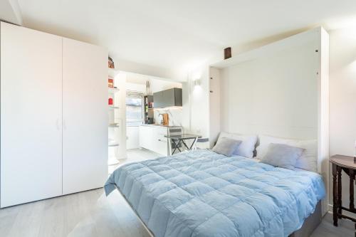 a bedroom with a large bed and a kitchen at Housmart Tovaglie 9 int 7 in Bologna