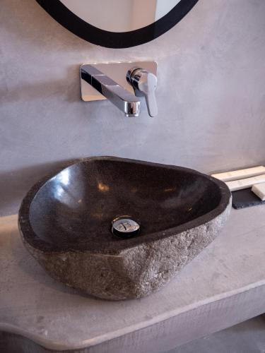a stone sink in a bathroom with a mirror at Caldera Cliff Illusion in Fira