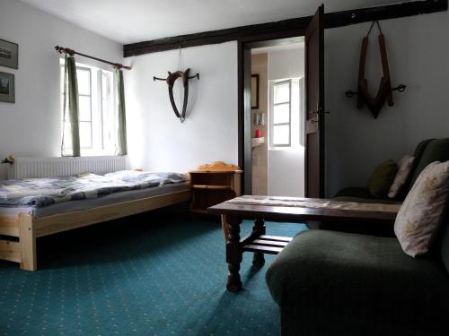 a bedroom with a bed and a table and a couch at U Uhlířu in Liberec