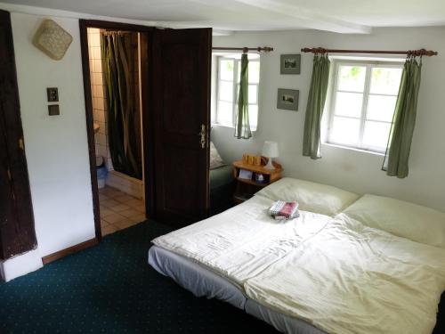 1 dormitorio con 1 cama blanca y 2 ventanas en U Uhlířu, en Liberec