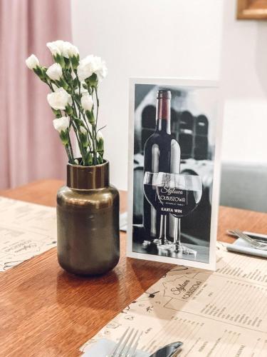 a vase with flowers and a picture of a bottle of wine at Stylowa Kolbuszowa in Kolbuszowa