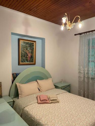 a bedroom with a bed with a pink towel on it at Villa Lochia - Καλημέρι in Elafopídima