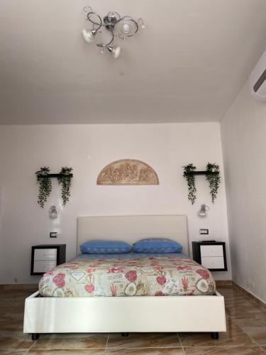 a bedroom with a bed and a chandelier at L'oasi del Tuffatore in Agropoli