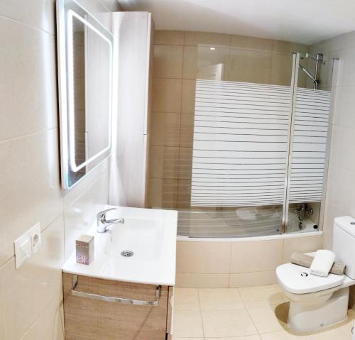 uma casa de banho com um lavatório, um chuveiro e um WC. em Benalbeach Casa KITO Dreams 1ª Línea Playa em Benalmádena