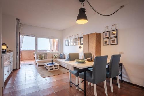 a dining room and living room with a table and chairs at LA BRIOSA-INFINITYHOLIDAYS in Costa Paradiso