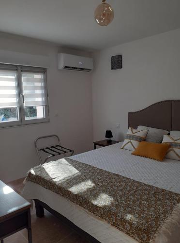 une chambre avec un grand lit et deux fenêtres dans l'établissement Gite La vallée du silence, au Beausset