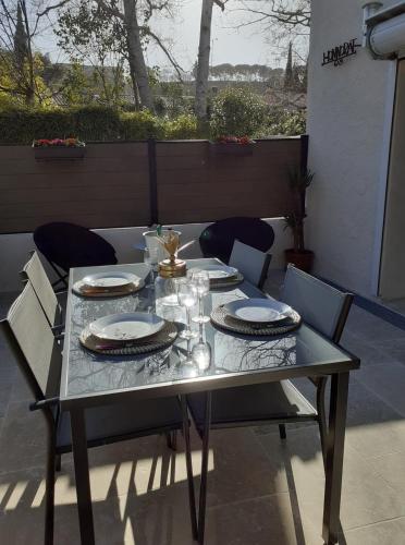 - une table avec des assiettes et des verres sur la terrasse dans l'établissement Gite La vallée du silence, au Beausset