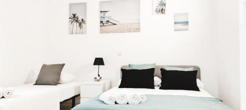 a white room with two beds and a table at Benalbeach Casa KITO Dreams 1ª Línea Playa in Benalmádena