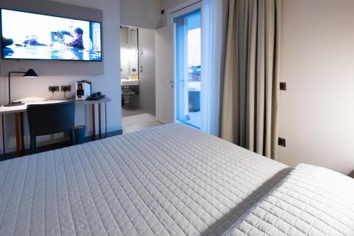 1 dormitorio con 1 cama y TV en la pared en BBCUBE, en Porto Viro