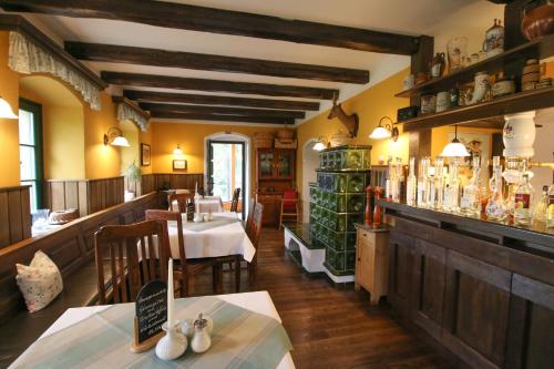 a restaurant with a dining room with tables and chairs at Altsächsischer Gasthof Kleines Vorwerk in Sayda