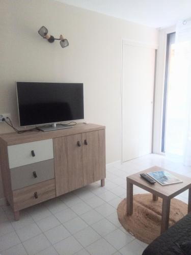 - un salon avec une télévision à écran plat sur une armoire en bois dans l'établissement Frejus Plage, Appartement entier , piscine,parking,plage à 200m, à Fréjus