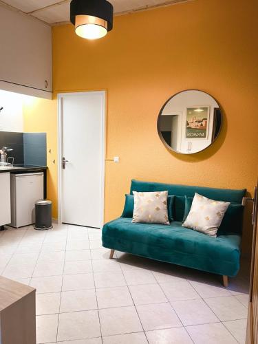 ein Wohnzimmer mit einem blauen Sofa und einem Spiegel in der Unterkunft Bright Apt For Two At 8 Min From Utopia Cinema in Avignon