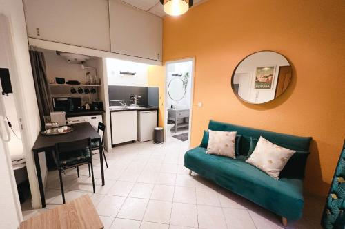 ein Wohnzimmer mit einem grünen Sofa und einer Küche in der Unterkunft Bright Apt For Two At 8 Min From Utopia Cinema in Avignon
