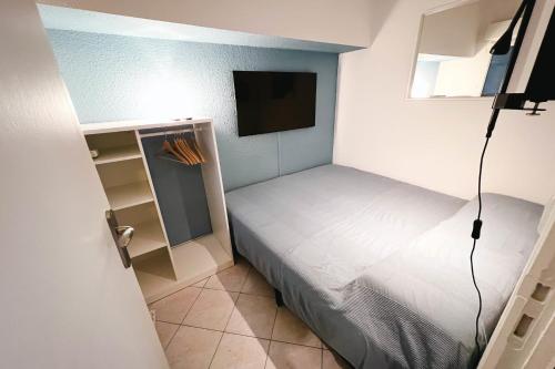 Kleines Zimmer mit einem Bett und einem TV in der Unterkunft Bright Apt For Two At 8 Min From Utopia Cinema in Avignon
