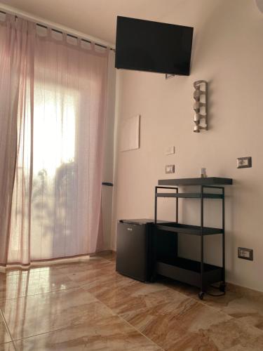 a living room with a television on the wall and a table at L'oasi del Tuffatore in Agropoli